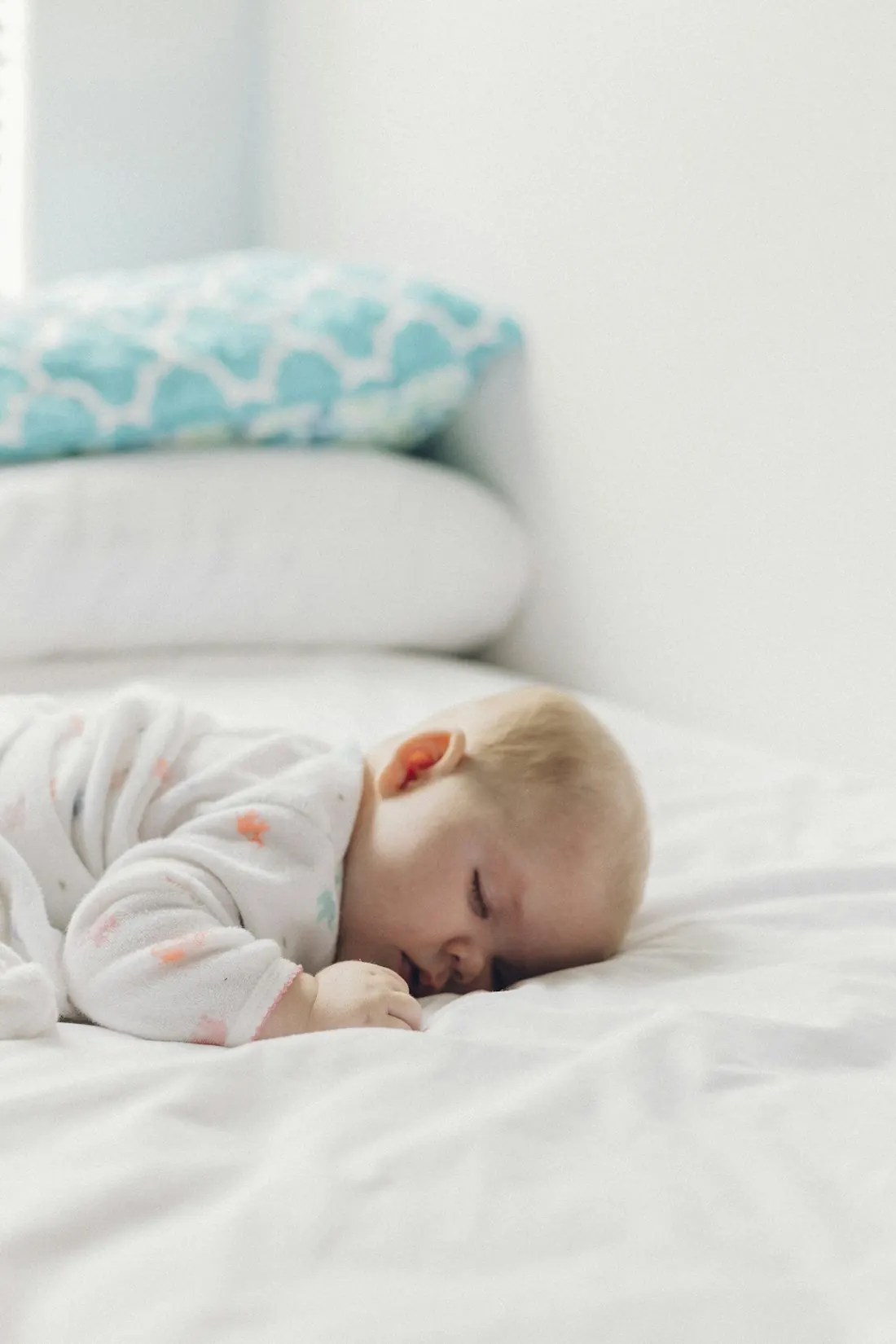 Un bebé dormido boca abajo sobre la cama de casa